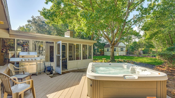 A backyard with a hot tub, a barbecue grill, and a covered patio area. - Spacious Home w/ Hot Tub in Fort Walton Beach! (Fort Walton Beach)