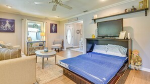 A bedroom with a bed, a ceiling fan, a TV, and a small table. - Spacious Home w/ Hot Tub in Fort Walton Beach! (Fort Walton Beach)