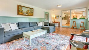 A living room with a grey sectional sofa, a white coffee table, and a patterned rug. - Sand Lake Retreat: Canal Access & Large Yard! (Onsted)
