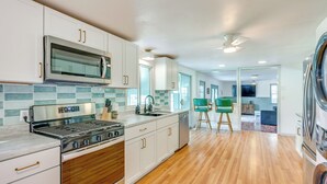 A modern kitchen with white cabinets, a stainless steel microwave, a gas stove, and a dishwasher. - Sand Lake Retreat: Canal Access & Large Yard! (Onsted)