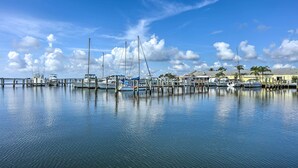 Un port de plaisance avec des bateaux amarrés à des quais en bois, une eau calme et un ciel dégagé.