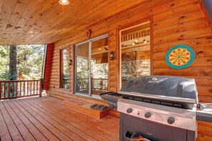 Una terraza de madera con una parrilla y un dardo.