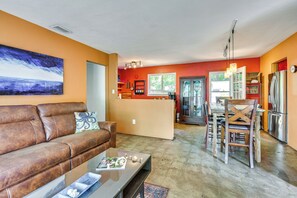 Ein Wohnzimmer mit braunem Ledersofa, einem Couchtisch und einem Gemälde an der Wand.