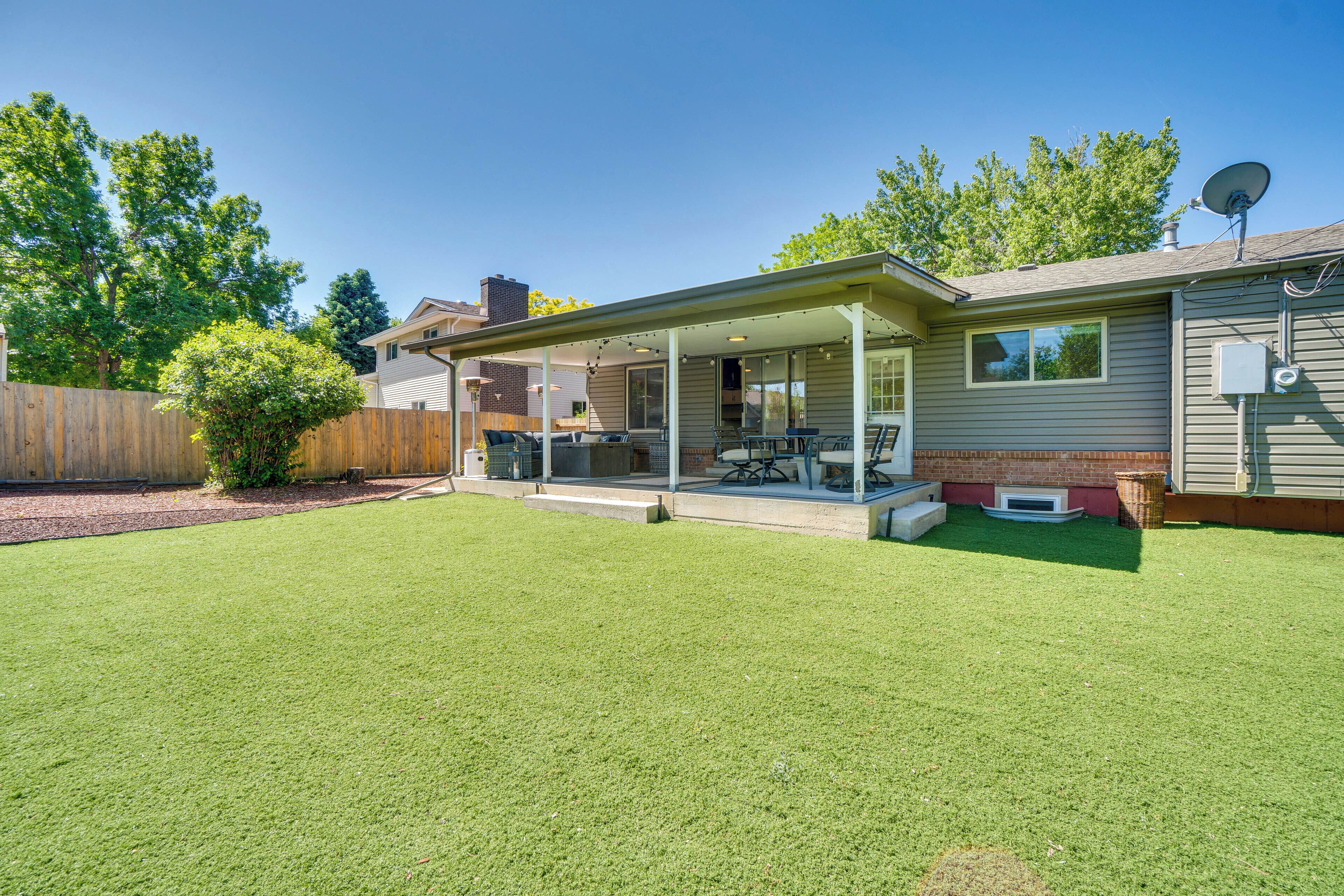 A house with a covered patio, a lawn, and a satellite dish.