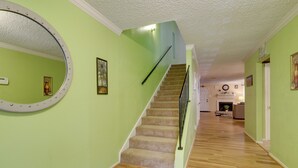 Un escalier avec une rampe, des marches recouvertes de moquette et un plancher en bois.