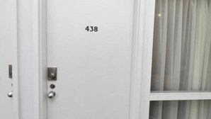 A white door with the number 438, a keypad lock, and a keyhole. - Unwind Adelaide City Studio No 438 (Adelaide)