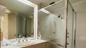A modern bathroom with a glass-enclosed shower, a large mirror, and a dual sink vanity. - Unwind Adelaide City Studio No 438 (Adelaide)