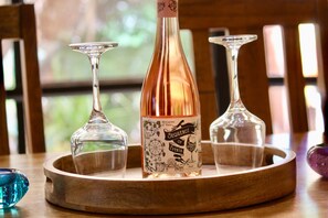 A bottle of McLaren Vale wine on a wooden tray with three wine glasses.