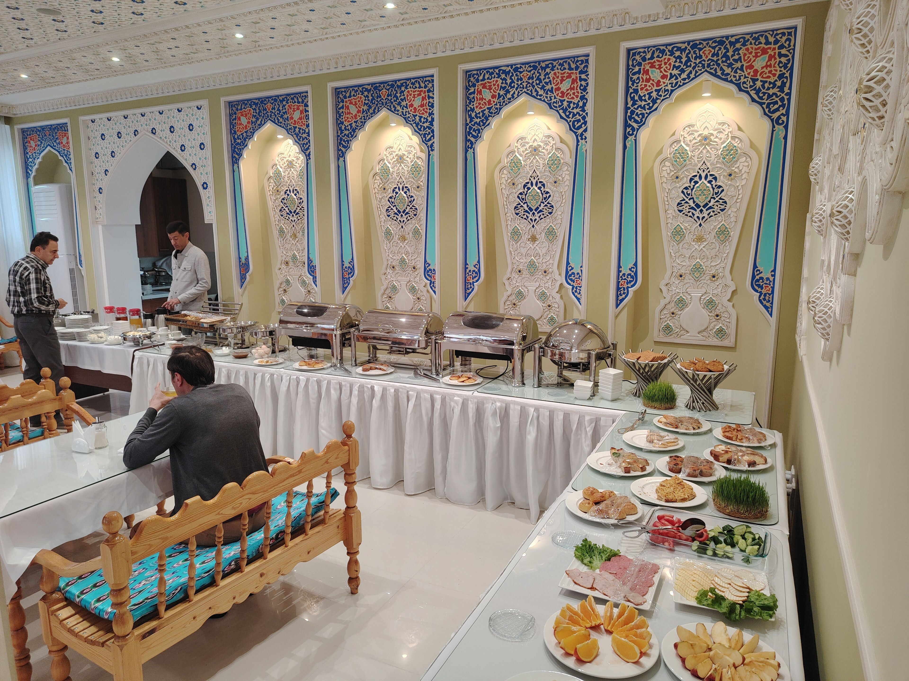 A buffet setup with food items and a person serving.
