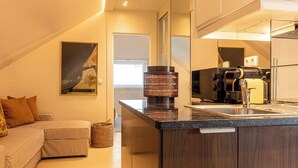 Una cocina moderna con una isla integrada, una cafetera y un refrigerador.