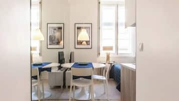 Ein moderner, gut beleuchteter Raum mit Essbereich, Computertisch und Fenster für natürliches Licht.