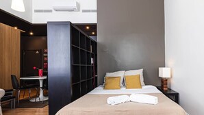 A hotel room with a bed, a desk, and a bookshelf. - Well-located Studio with Smart Space (Lisbon)