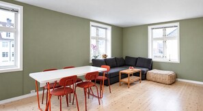 A room with a white table, red chairs, a grey sofa, and a small wooden table. - Quiet place near city centre and the mountains (Vestland)