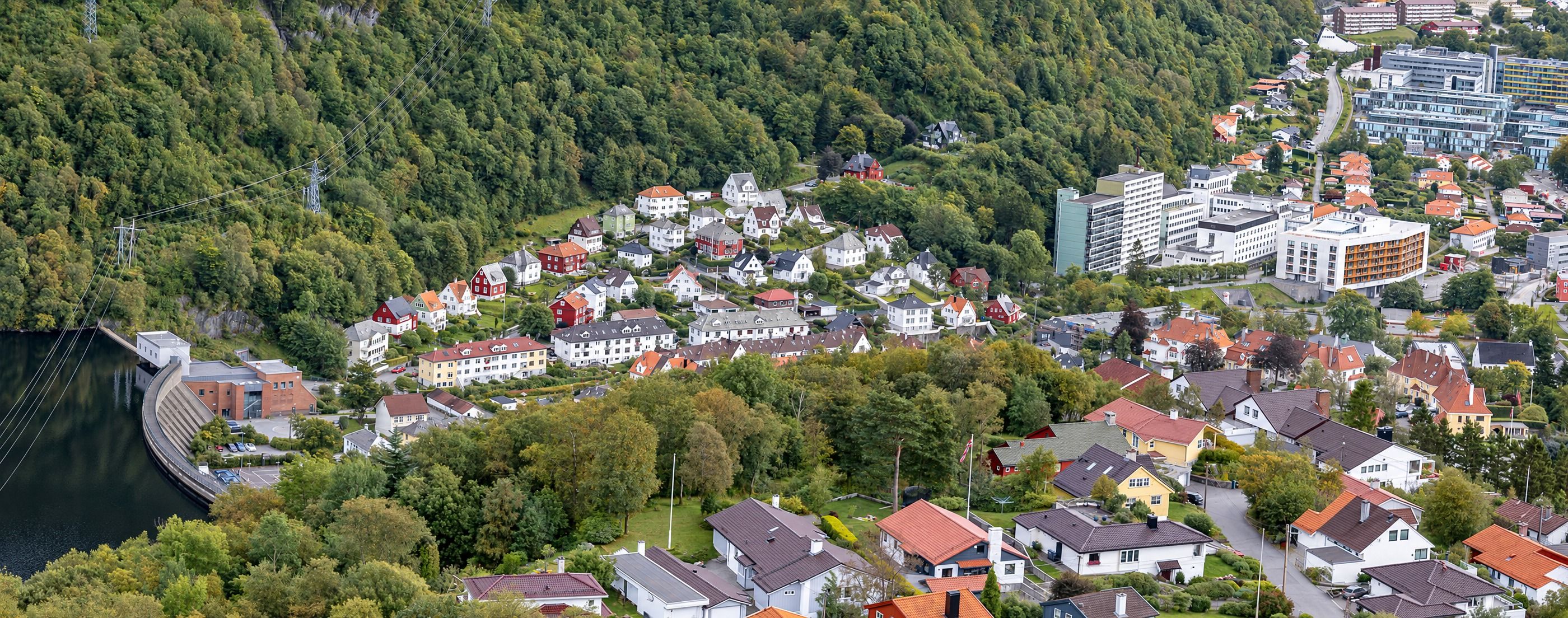 Un quartier résidentiel avec des maisons, un barrage et un mélange d’architecture moderne et traditionnelle.