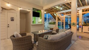 Een knus terras met rieten meubels en een vuurplaats.
