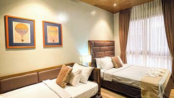 Une chambre d’hôtel avec deux lits, un plafond en bois et des œuvres d’art encadrées accrochées au mur.