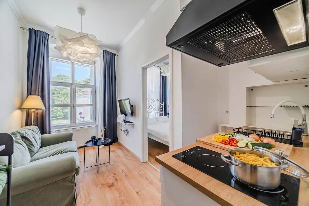Une cuisine moderne équipée d’une cuisinière, d’un coin repas avec une table et des chaises, et offrant une vue sur l’extérieur grâce à de grandes fenêtres.