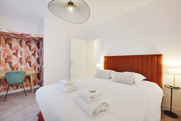A hotel room with a large bed, a desk, and a chair. - Cosy appartement - 1BDR/4P - Boulogne Billancourt (Boulogne-Billancourt)