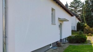 Un edificio moderno con fachada blanca, una ventana pequeña y una puerta.