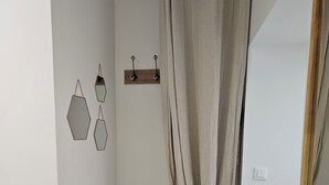 A room with a wooden bench, a woven basket, and a wall-mounted coat rack with a coat and a hat. - Vineyard and Chateau Stay Vouvray (Vouvray)