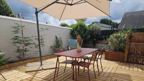 A wooden deck with a red table and chairs, an umbrella, and potted plants. - Vineyard and Chateau Stay Vouvray (Vouvray)