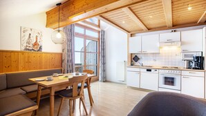 Una cocina moderna con gabinetes blancos, horno empotrado y microondas.