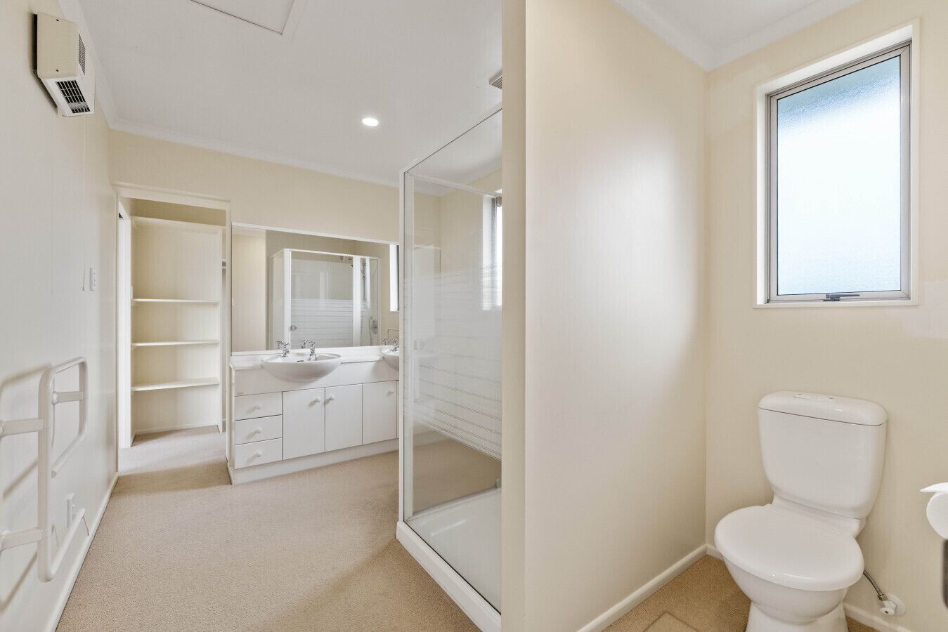 A modern bathroom with a walk-in shower, a toilet, and a sink with a large mirror.