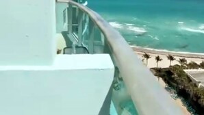 Un balcon avec vue sur l’océan et une plage.