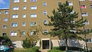Un edifici d'apartaments de diversos pisos amb façana uniforme, nombroses finestres i una entrada central.
