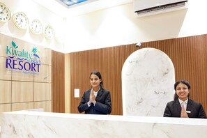 Een receptiebalie bij Kwality Beach Resort, met houten lambrisering en marmeren accenten.