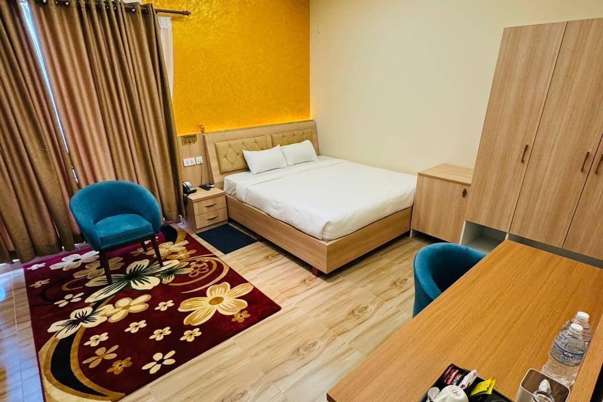 Ein Hotelzimmer mit Bett, Schreibtisch mit Stuhl, Kleiderschrank und Bad.