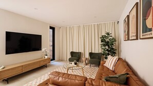 A modern living room with a large flat-screen TV, leather sofa, two armchairs, a coffee table, and a potted plant.