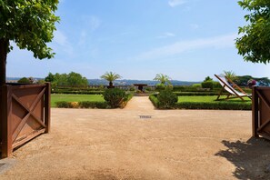 A gravel pathway leading to a seating area with a view of a landscaped garden and distant hills. - Studio with Shared Pool, Wi-Fi, and Air Conditioning (Montayral)
