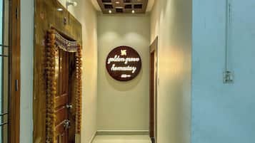 A hallway with a wooden door on the left, a wall-mounted sign reading "golden grove harnessary," and a ceiling with recessed lighting.