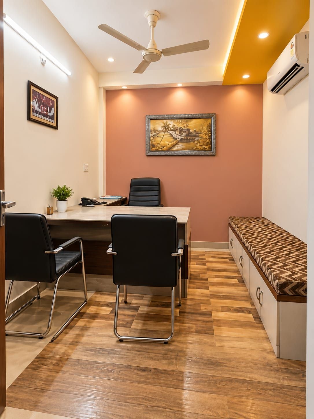 A conference room with a table, chairs, a ceiling fan, and a painting on the wall.