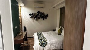 Un dormitorio moderno con cama, escritorio y aire acondicionado instalado en la pared.