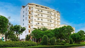 Ein mehrstöckiges Hotel mit weißer Fassade, mehreren Balkonen und Klimaanlagen.