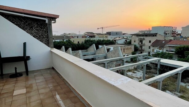 A rooftop terrace with a view of the cityscape at sunset. - Mistral's House - Apartment in the heart of Alghero (Alghero)