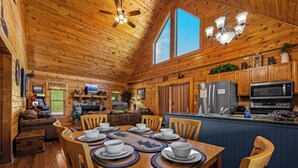 A wooden cabin interior with a dining area, kitchen, and living room. - Free Dollywood Tix/HotTub/Dog Friendly/A+ Location (Sevierville)