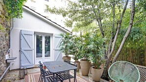 A patio with a table and chairs, surrounded by potted plants and a bamboo fence. - Charming house -2BR-4P- Ivry-sur-seine (Ivry-sur-Seine)