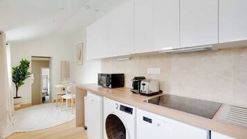 A modern kitchen with white cabinets, a built-in microwave, toaster, and dishwasher.
