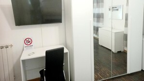 A modern office space with a desk, chair, and a mounted flat-screen TV. - Le Stanze dei Ghibellini (Florence)