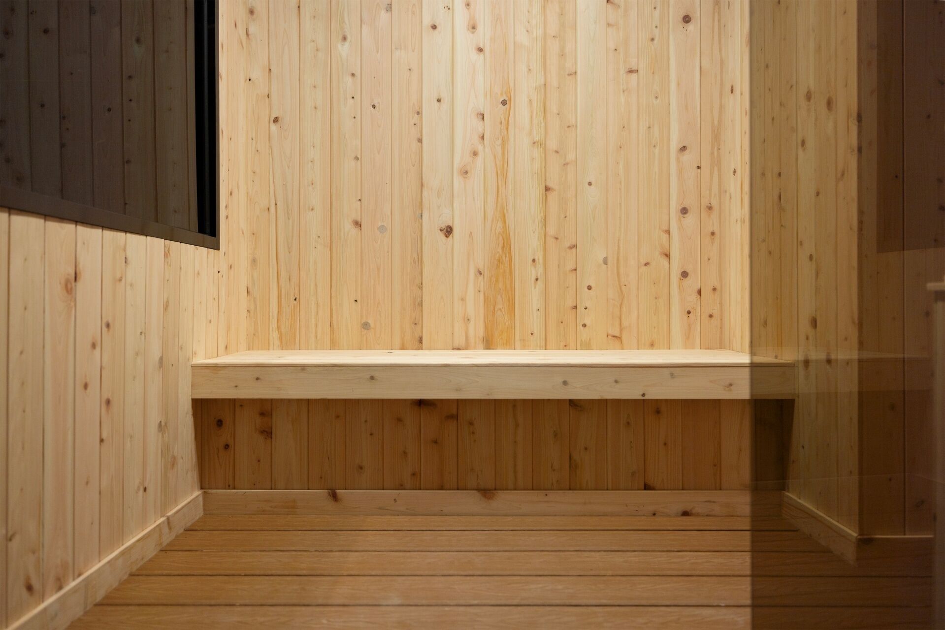 Un interior de madera con un banco y piso de madera.