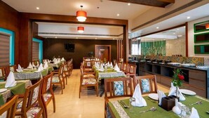 Een restaurant met verschillende eettafels, stoelen en een keukenhoek.