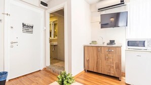 A compact kitchen with a microwave, a sink, and a cabinet.