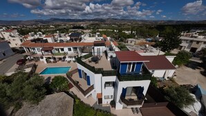 A residential area with a swimming pool, multiple balconies, and a view of distant mountains. - Penthouse with Rooftop & Mountain View - Between Sea, Nature & Relaxation (Poli Chrysochous)