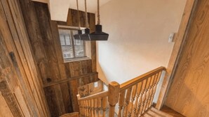 Eine Holztreppe mit Glastrennwand und einer Pendelleuchte.