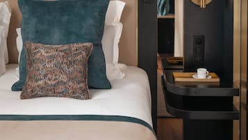 A hotel room with a bed, a nightstand, a lamp, and a painting on the wall.