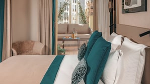 Una camera d'albergo con un letto, un divano e un balcone con vista sugli edifici.
