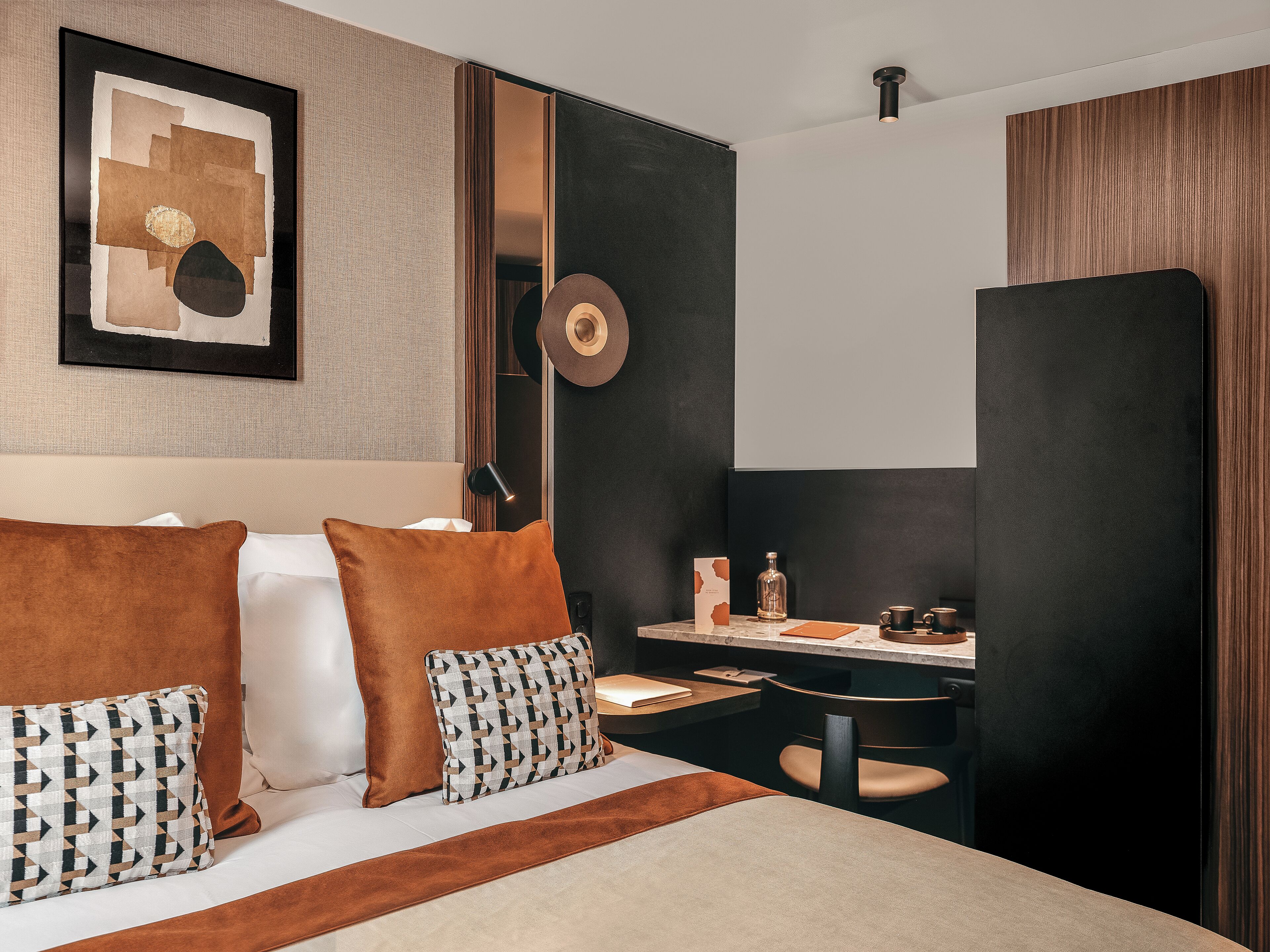 Una habitación de hotel moderna con una cama, un escritorio y una silla.